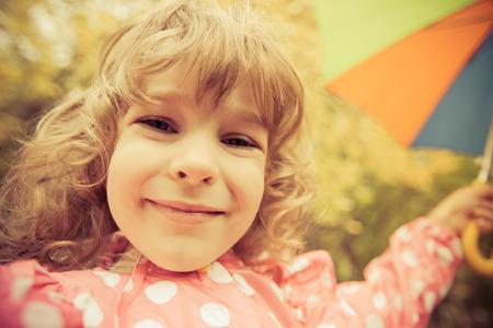 Happy child playing outdoors in autumn parkの写真素材