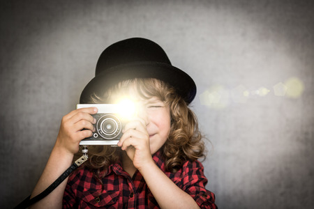 Hipster kid taking a photo using vintage film cameraの写真素材