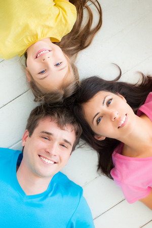 Portrait of happy family lying on floor at homeの写真素材