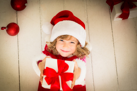 Child holding Christmas gift. Xmas holiday conceptの写真素材