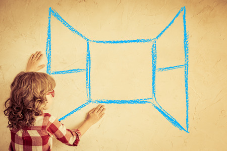 Kid looking out of the drawn open window on grunge wall. Freedom conceptの写真素材