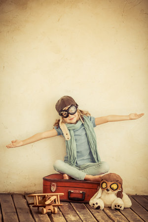 Happy child playing with toy airplane at home. Retro tonedのeditorial素材