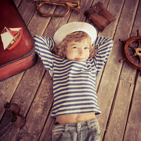 Happy kid dressed in sailor. Child playing at home. Travel and adventure conceptの写真素材