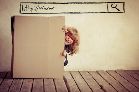 Portrait of young businessman in cardboard box. Think outside the box. Internet search technology. Copy space for your textの写真素材