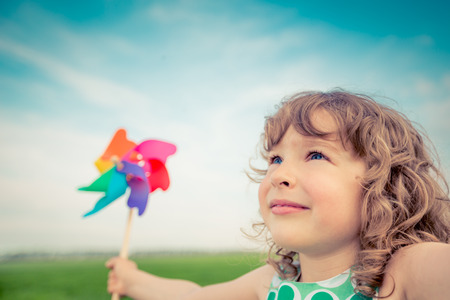 Happy child in spring field. Young girl relax outdoors. Freedom conceptの写真素材