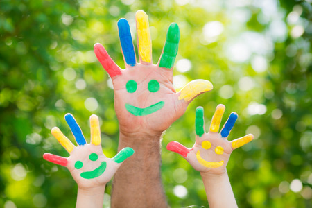 Smiley on hands against green spring backgroundの写真素材