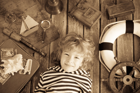 Happy kid playing with nautical things. Child having fun at home. Travel and adventure concept. Unusual high angle view portraitの写真素材