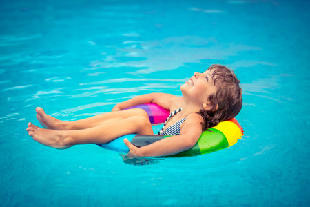 Happy child playing in swimming pool. Summer vacation concept