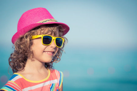 Happy child against sea and sky background. Summer vacation and travel conceptの写真素材