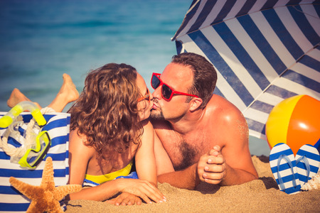 Happy couple in love. People lying on the beach. Young man and woman kissing. Summer vacation conceptの写真素材