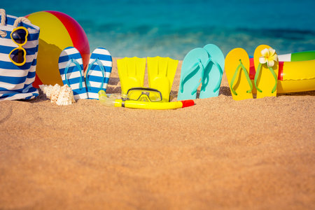 Flip-flops, beach ball and snorkel on the sand. Summer vacation concept