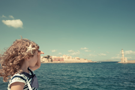 Sailor kid looking through the binoculars against blue sky の写真素材