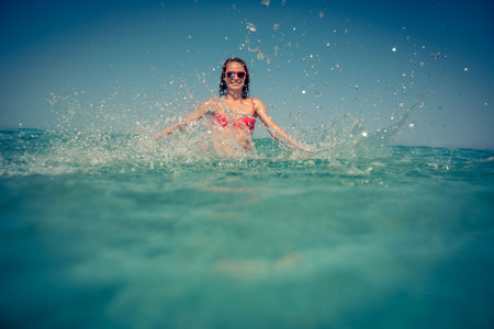 Young woman playing in the sea. Summer vacation conceptの写真素材