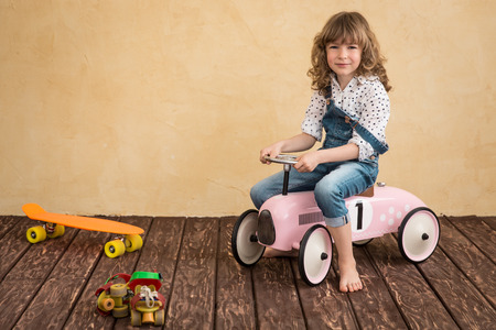 Happy child playing at home. Car trip. Summer vacation and travel conceptの写真素材