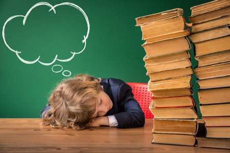 School kid in class. Happy child against green blackboard. Education conceptの写真素材