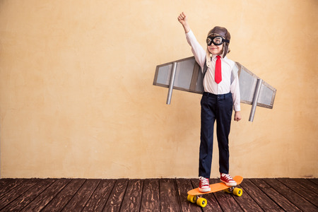 Portrait of young businessman with toy paper wings. Success, creative and startup concept. Copy space for your text