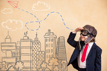 Portrait of young businessman with drawn airplane over city. Success, creative and startup concept Portrait of young businessman with drawn airplane over city. Success, creative and startup concept
