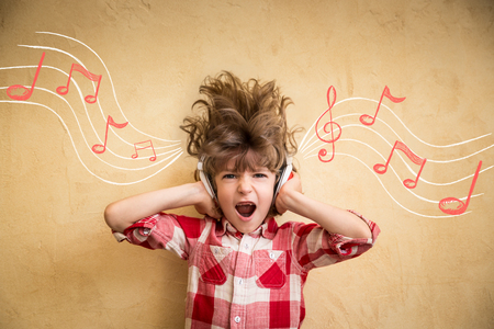 Kid listen music at home. Hipster child with headphones. Retro music conceptの写真素材