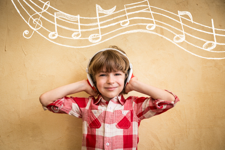 Kid listen music at home. Hipster child with headphones. Retro music conceptの写真素材