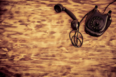 Retro phone on wooden background. Top viewの写真素材