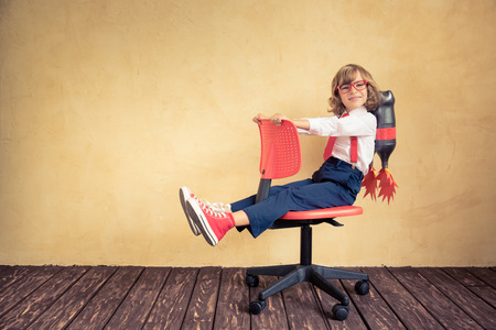 Portrait of young businessman with jet pack riding office chair. Success, creative and innovation technology concept. Copy space for your textの写真素材