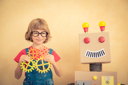 Funny nerd child with toy robot. Innovation technology and success conceptの写真素材