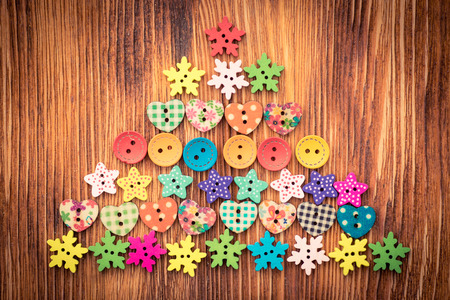 Christmas tree of buttons on wood background. Xmas holiday conceptの写真素材