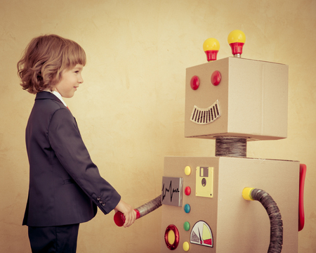 Portrait of young businessman with toy robot in modern loft office. Success, creative and innovation technology concept. Copy space for your textの写真素材