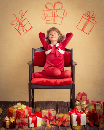 Child dreaming in armchair. Christmas gift. Xmas holiday conceptの写真素材