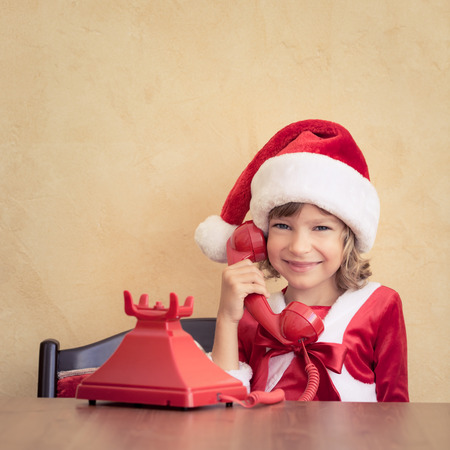 Child talking by phone. Christmas support. Xmas holiday conceptの写真素材