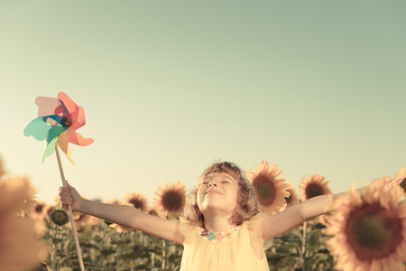 Happy child having fun in spring field against blue sky background. Freedom conceptの写真素材
