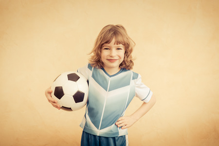Child is pretending to be a soccer player. Success and winner conceptの写真素材