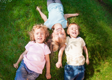 Group of happy children playing outdoors in spring park. Top view portraitの写真素材