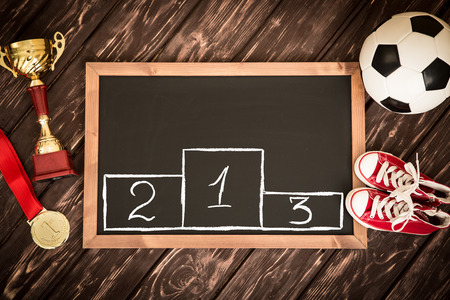 Blackboard with drawn soccer game strategy. Ball, trophy and medalの写真素材