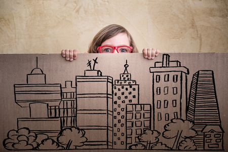 Funny child businessman hiding behind banner. Success, creative and business conceptの写真素材