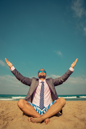 Portrait of funny businessman on the beach. Man having fun by the sea. Summer vacation and travel conceptの写真素材
