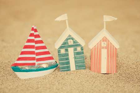 Toy house on sandy beach against blue sea and sky background. Summer vacation conceptの写真素材