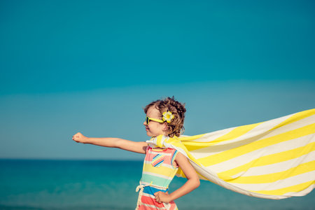 Child having fun on the beach against sea and sky background. Summer vacation and travel conceptの写真素材