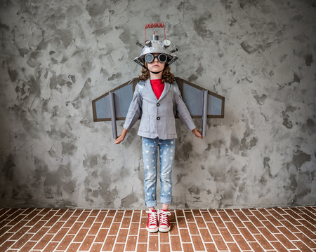 Portrait of young child pretend to be businessman. Kid with toy virtual reality headset in modern loft office. Success, creative and innovation technology concept. Copy space for your textの写真素材