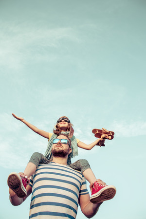 Kid with jet pack pretend to be superhero. Child playing with father in summer. Happy dad and son outdoors. Success, leader and winner conceptの写真素材