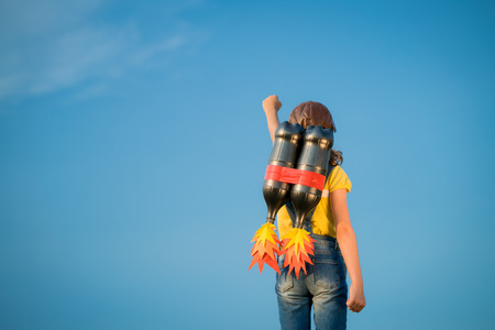 Kid with jet pack pretend to be superhero. Child playing in summer outdoors. Success, leader and winner conceptの写真素材