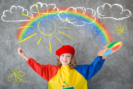 Happy child playing at home. Drawing autumn theme. Imagination and freedom conceptの写真素材