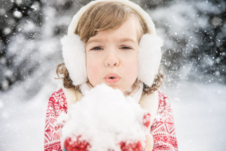 Happy child playing outdoors. Kid having fun in winter parkの写真素材