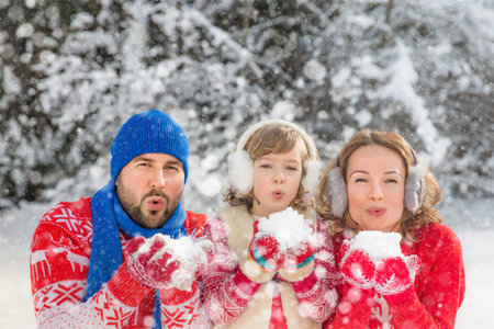 Happy family playing outdoors. People having fun in winter park