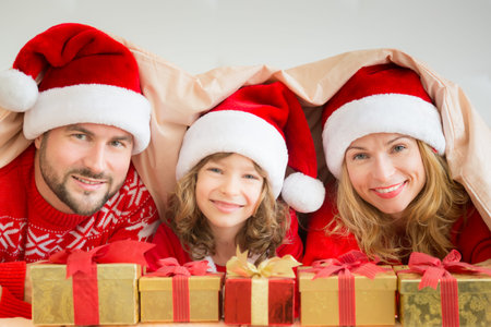 Happy family in bedroom. Mother, father and child indoors. People having fun at home. Christmas Xmas New Year winter holiday conceptの写真素材