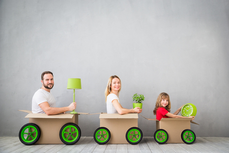 Happy family playing into new home. Father, mother and child having fun together. Moving house day and express delivery conceptの写真素材