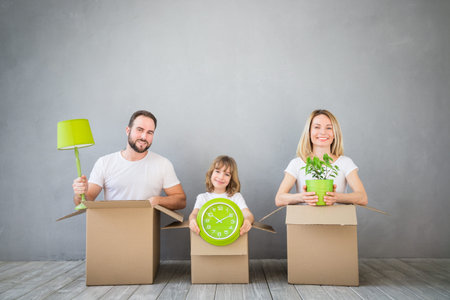 Happy family playing into new home. Father, mother and child having fun together. Moving house day...