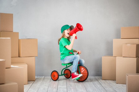 Happy child playing into new home. Kid having fun indoor. Moving house day and express delivery conceptの写真素材