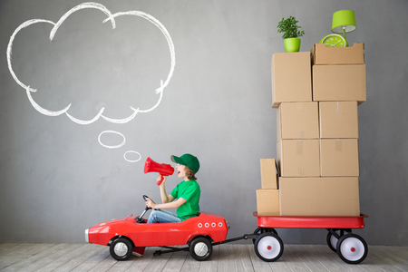 Happy child playing into new home. Kid having fun indoor. Moving house day and express delivery conceptの写真素材