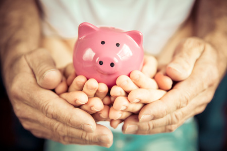Family holding piggybank in hands. Investment conceptの写真素材